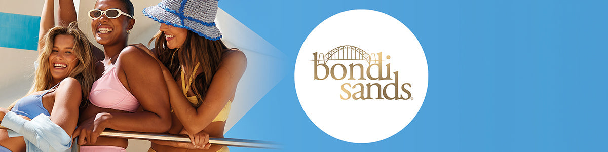 Werbung für Bondi Sands mit drei fröhlichen Frauen in Bademode und Bräunungs- sowie Sonnenpflegeprodukten vor blauem Hintergrund.