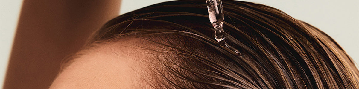 Mit einer Pipette wird Flüssigkeit auf das nasse Haar aufgetragen.