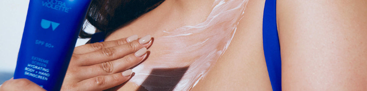 Eine Person trägt Sonnenschutzlotion auf Schulter und Dekolleté auf und hält dabei eine blaue Flasche von Ultra Violette SPF 50+.