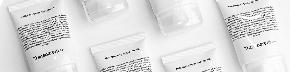 Fünf weiße Hautpflegetuben mit der Aufschrift „Transparent Lab Niacinamide Glow Cream“ auf weißem Hintergrund, von oben betrachtet.