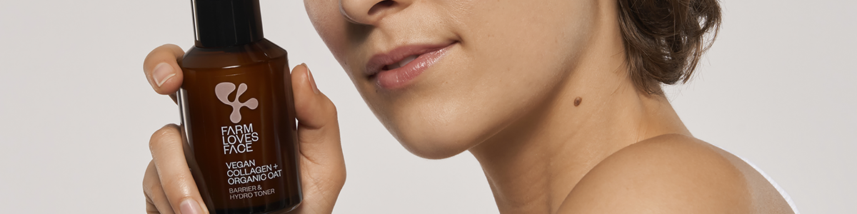 Frau hält eine braune Serumflasche der Marke neben ihrem Gesicht.