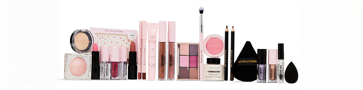 Vielfältige Make-up-Produkte in Rosa- und Nude-Tönen, darunter Lippenstifte, Lidschattenpaletten, Puder, Schwämmchen und Eyeliner, aufgereiht vor weißem Hintergrund.