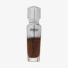 Eine halb transparente halb silberne Flasche Chroma Cover Foundation Luminous in der Farbe N10 vor weißem Hintergrund.