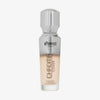 Eine halb transparente halb silberne Flasche Chroma Cover Foundation Luminous in der Farbe W1 vor weißem Hintergrund.