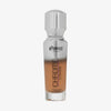Eine halb transparente halb silberne Flasche Chroma Cover Foundation Luminous in der Farbe W10 vor weißem Hintergrund.