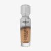 Eine halb transparente halb silberne Flasche Chroma Cover Foundation Luminous in der Farbe W7 vor weißem Hintergrund.