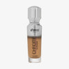 Eine halb transparente halb silberne Flasche Chroma Cover Foundation Luminous in der Farbe W9 vor weißem Hintergrund.