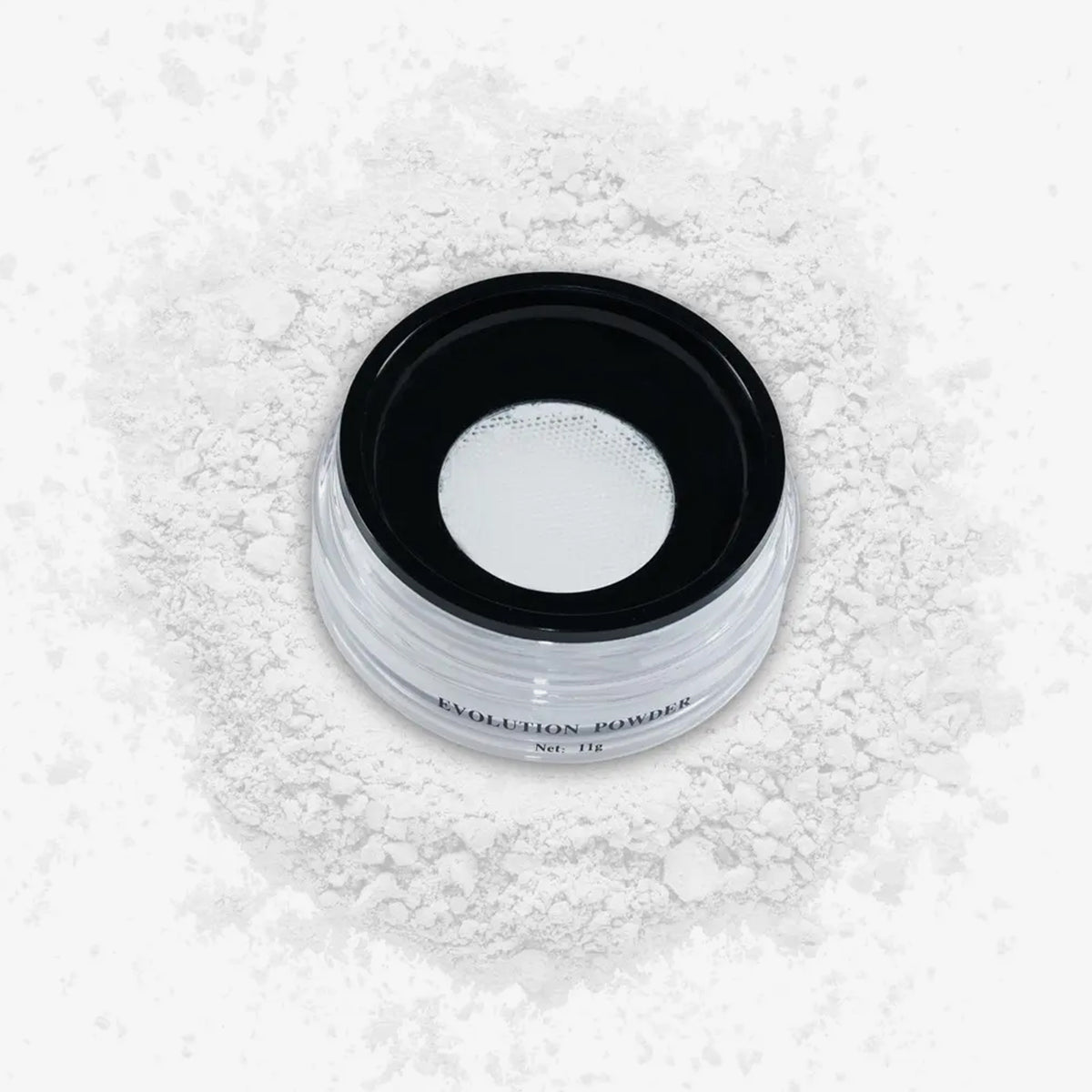 Ein transparenter Tiegel mit losem weißem Fixierpuder Evolution Powder #1 auf einer weißen Fläche, umgeben von Puder.