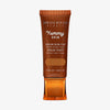 Bronzefarbene Tube der Yummy Skin Serum Tint 11 mit Sichtfenster zum warmem braunen Produktinhalt.