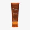 Bronzefarbene Tube der Yummy Skin Serum Tint 13 mit Sichtfenster zum dunkelbraunem Produktinhalt.