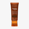Bronzefarbene Tube der Yummy Skin Serum Tint 14 mit Sichtfenster zum tiefbraunem Produktinhalt.