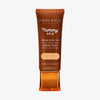 Bronzefarbene Tube der Yummy Skin Serum Tint 3 mit Sichtfenster zum mittelbeigen Produktinhalt.