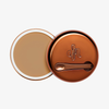 Runder geöffneter Behälter Yummy Skin Blurring Balm Shade 4 mit bronzefarbenem Deckel und kleinem Applikator.