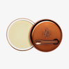 Runder geöffneter Behälter Yummy Skin Blurring Balm Shade Universal mit bronzefarbenem Deckel und kleinem Applikator.