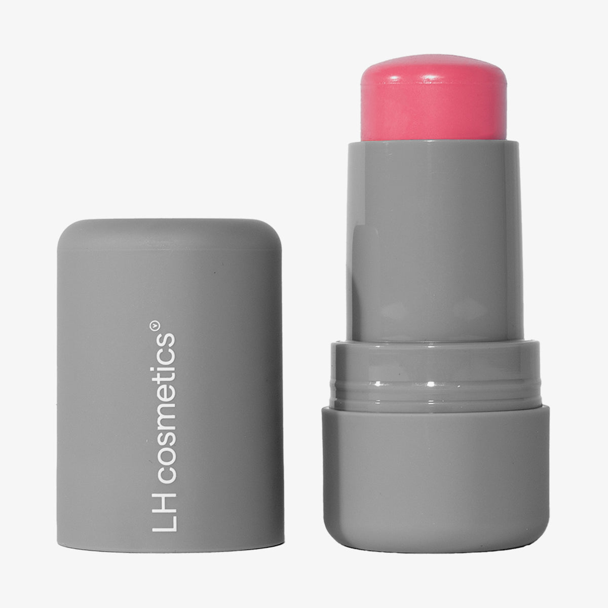 Neben der Tube steht eine graue Tube LH Cosmetics Artistick Blush mit einem leuchtend rosa Stift ohne Deckel.