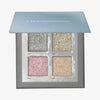 Geöffnete grau-blaue Aurora Palette von LH Cosmetics mit vier schimmernden Lidschatten in Blau-, Gold-, Rosa- und Champagnertönen.