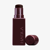 Eine rechteckige, weinrote Tube mit der Aufschrift NABLA Cosmetics enthält den Art Of Skin Foundation Stick, daneben steht die Kappe.