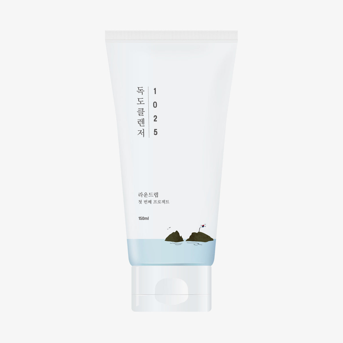 Eine weiße Tube 1025 Dokdo Cleanser, zeigt minimalistische Berg- und Wasserillustrationen auf der Verpackung.