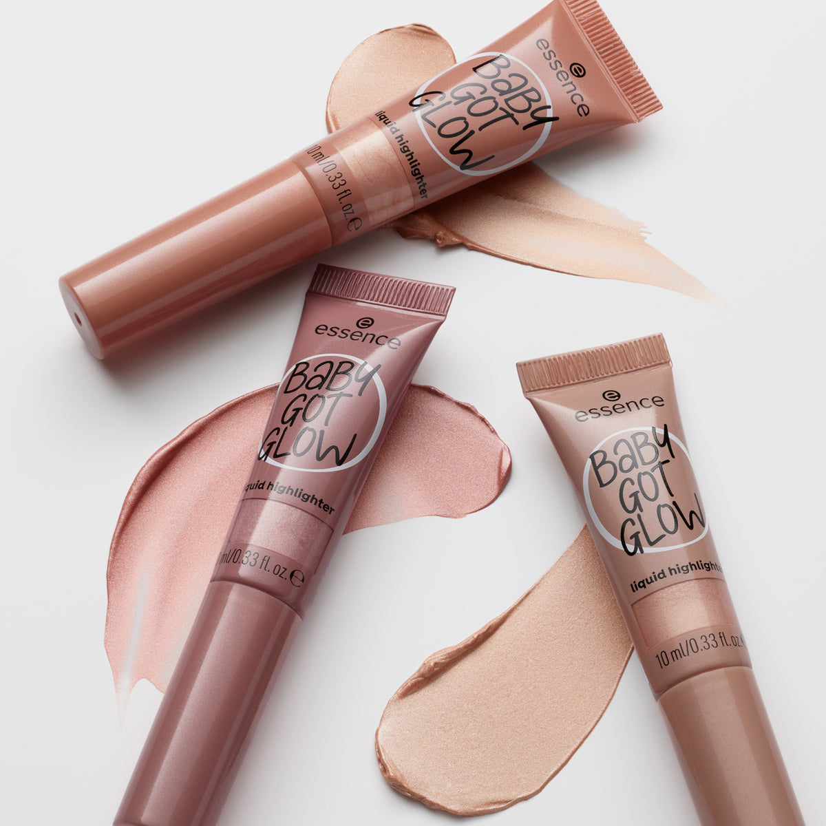 Drei Tuben BABY GOT GLOW liquid highlighter  mit Swatches vor weißem Hintergrund.