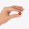 Eine Hand mit rosa Nägeln hält ein Gummy Stars™-Gummysternchen vor einem weißen Hintergrund.