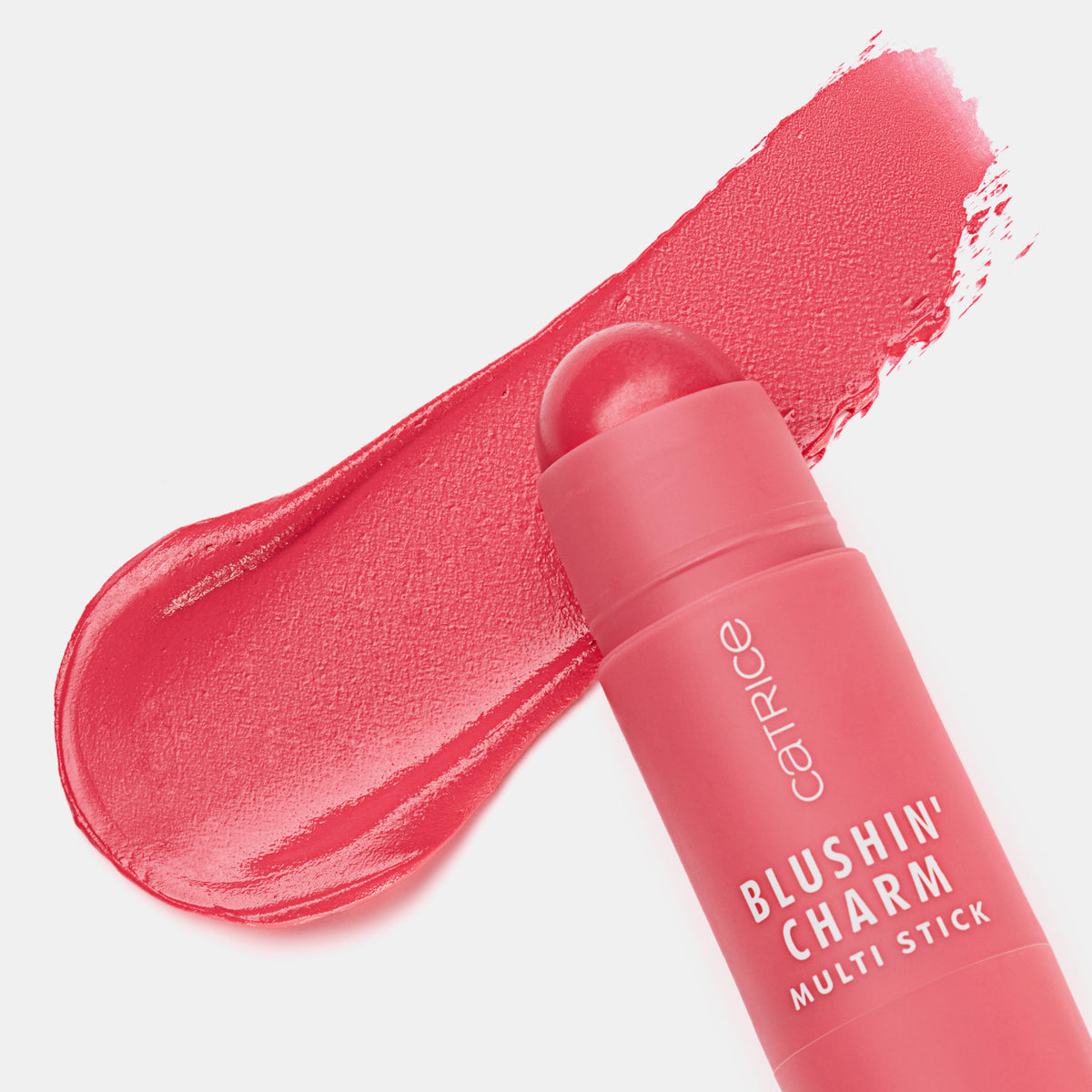 Blushin' Charm Multi Stick 010 mit runder Kuppe auf einem cremigen rosa-rotem Swatch auf weißer Oberfläche.