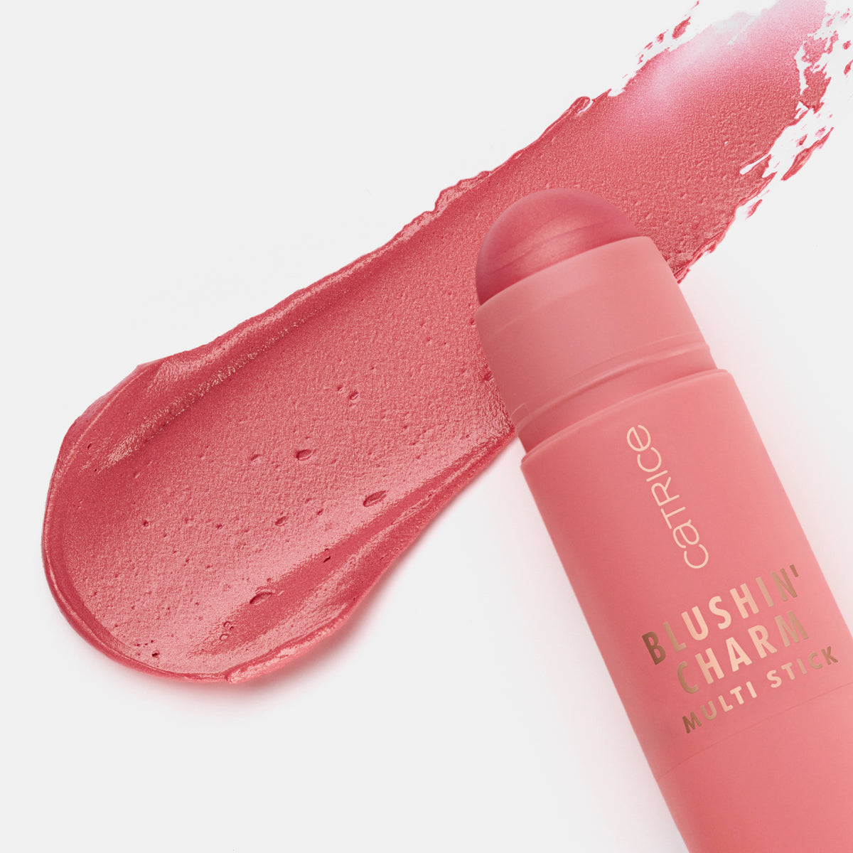 Blushin' Charm Multi Stick 040 mit runder Kuppe auf einem cremigen korallen-rosanem Swatch auf weißer Oberfläche.