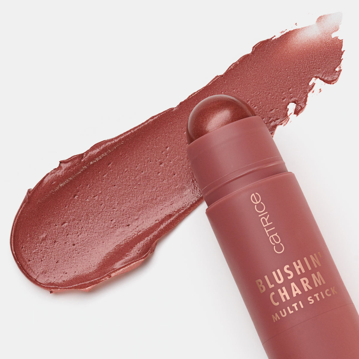 Blushin' Charm Multi Stick 050 mit runder Kuppe auf einem cremigen altrosa-braunem Swatch auf weißer Oberfläche.
