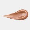 Ein glatter, glänzender Farbstreifen Melted Sun Liquid Bronzer 015 in warmem hellen braun vor weißem Hintergrund.