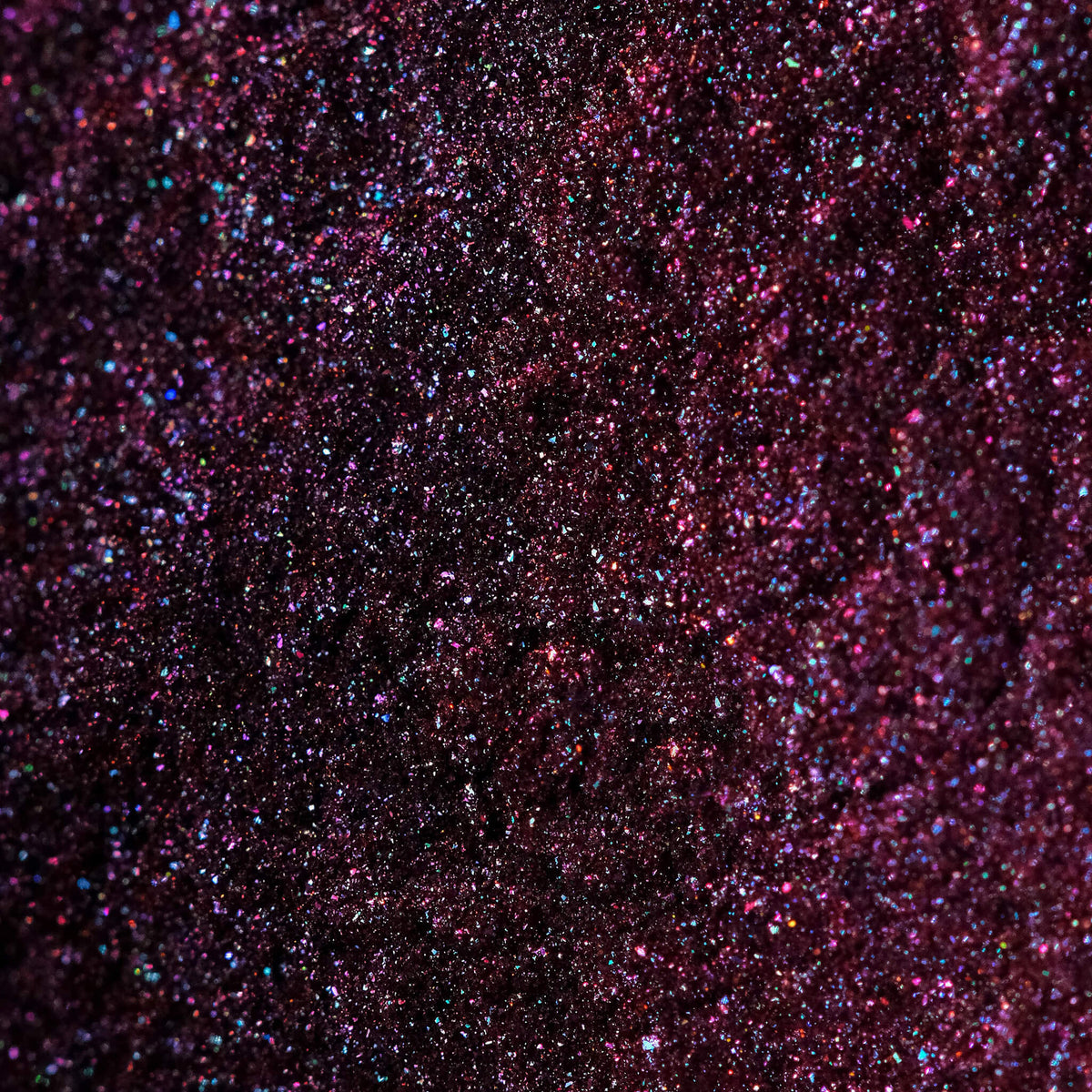 Nahaufnahme der Textur des Original Multichrome Loose Eyeshadow Lights Out; ein lila-pink schimmerndes Pigment.