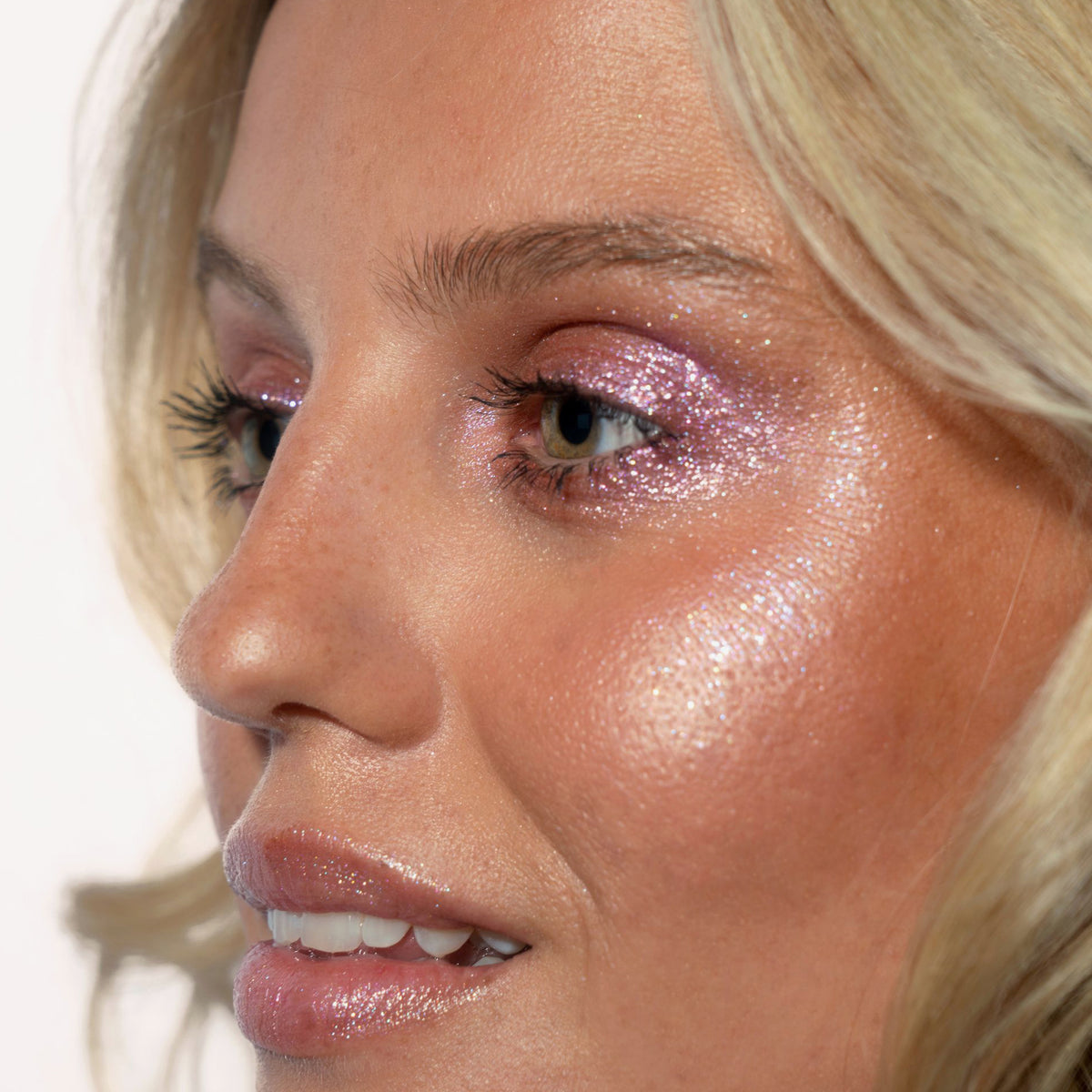 Nahaufnahme des Gesichts einer Frau mit pink glitzerndem Lidschatten Sparkl Adore von LH Cosmetics.