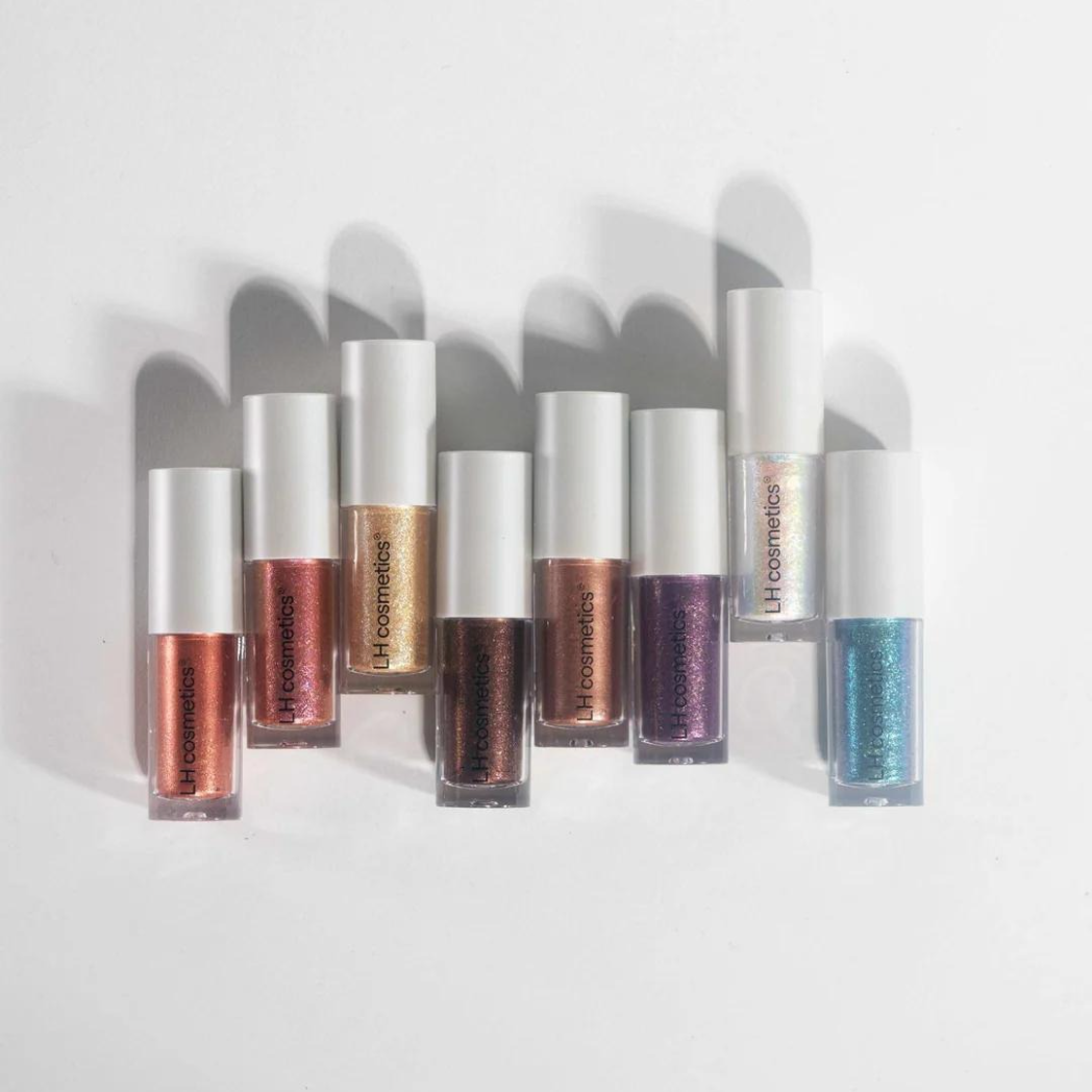 Neun schimmernde Sparkl-Lidschatten von LH Cosmetics in verschiedenen Farben, stehend nebeneinander auf weißem Hintergrund.