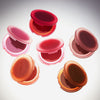 Sechs geöffnete Close-Up Blurring Powder Blush-Kompaktdosen in verschiedenen Farbtönen sind kreisförmig auf hellem Untergrund angeordnet.