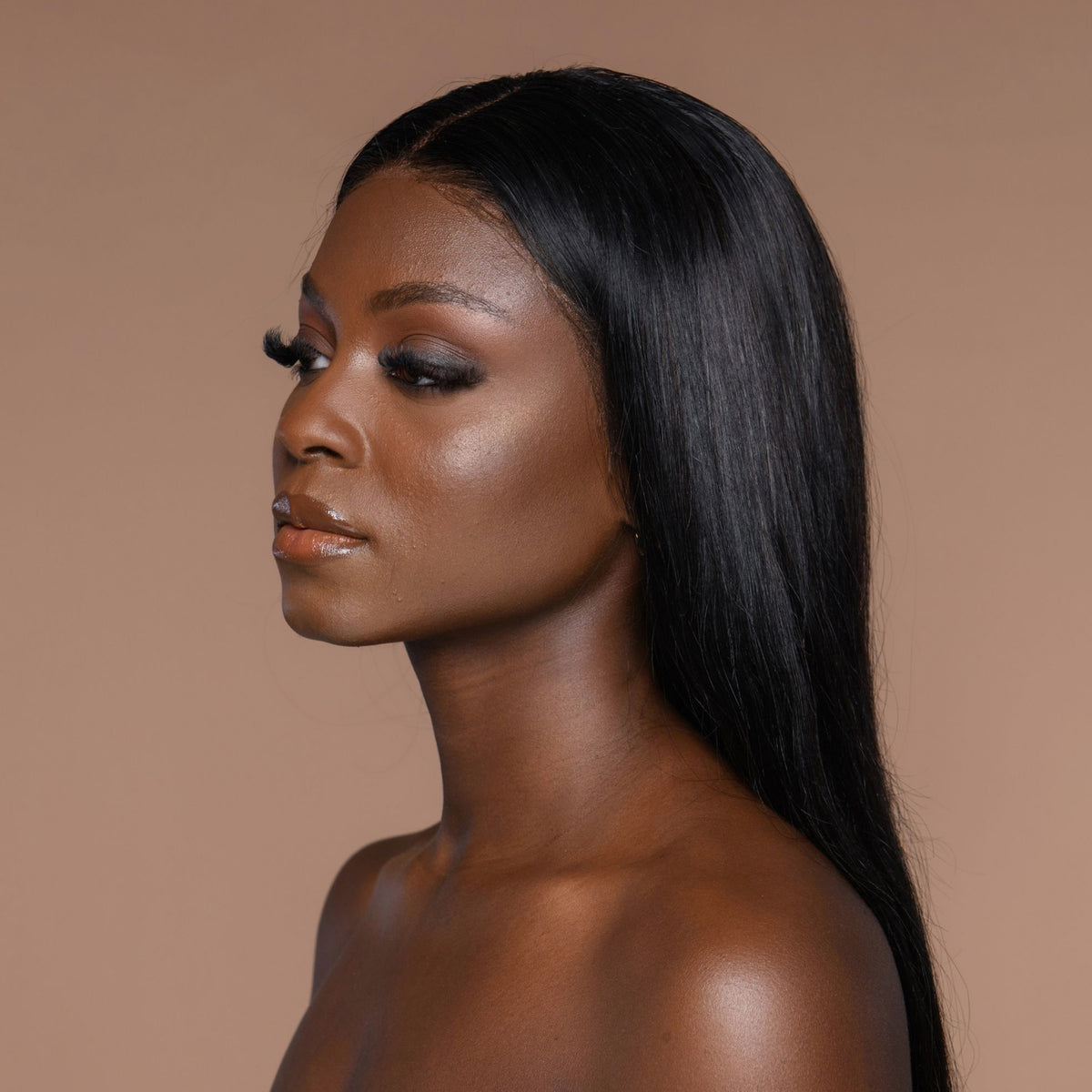 Person mit glattem langem Haar und neutralem Make-up zeigt den Cronzer Cream Bronzer Oak vor beigem Hintergrund.