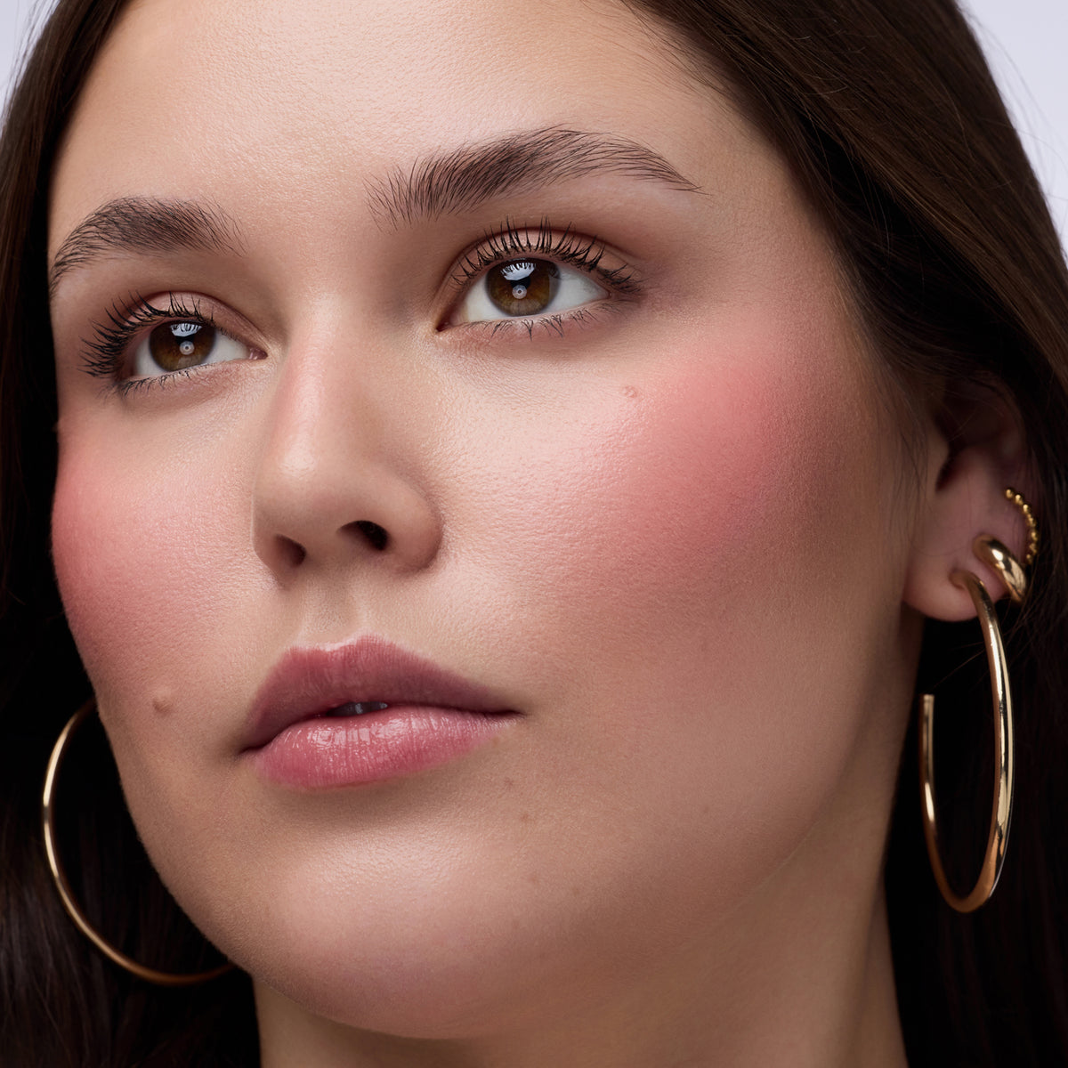 Nahaufnahme einer Frau die den Blushin' Charm Multi Stick 020 auf den Wangen und Lippen trägt.