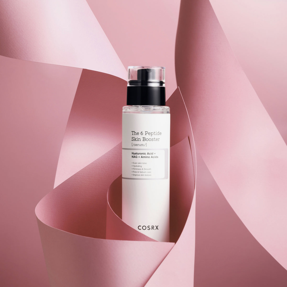 Eine Flasche des 6 Peptide Skin Booster Serum von COSRX von gewelltem rosa Papier Umgebung auf einem pastellrosa Hintergrund.
