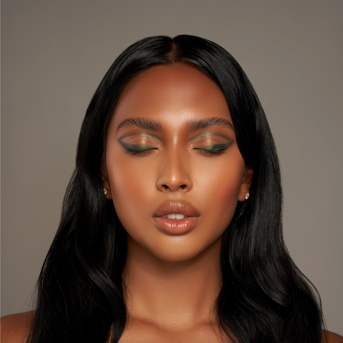Eine Frau mit mittelbraunem Teint präsentiert Make-up-Look mit grün-schimmerndem Infinite Chrome Pencil.