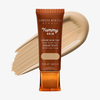 Eine Tube Yummy Skin Serum Tint 4.5 vor einem beigem Farbmuster.