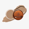 Runde geöffnete bronzefarbene Dose des Yummy Skin Blurring Balm Powder vor einem Farbstreifen der Shade 3.75