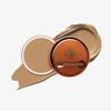 Runde geöffnete bronzefarbene Dose des Yummy Skin Blurring Balm Powder vor einem Farbstreifen der Shade 4.