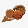 Runde geöffnete bronzefarbene Dose des Yummy Skin Blurring Balm Powder vor einem Farbstreifen der Shade 7.