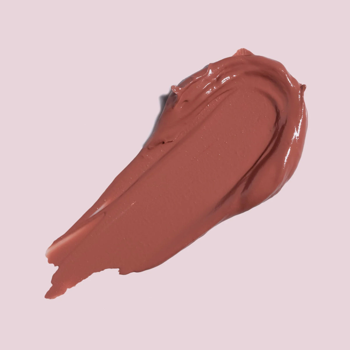 Ein Hauch von Cream Matte Liquid Lipstick in Malve-Pink auf einem blassrosa Hintergrund.