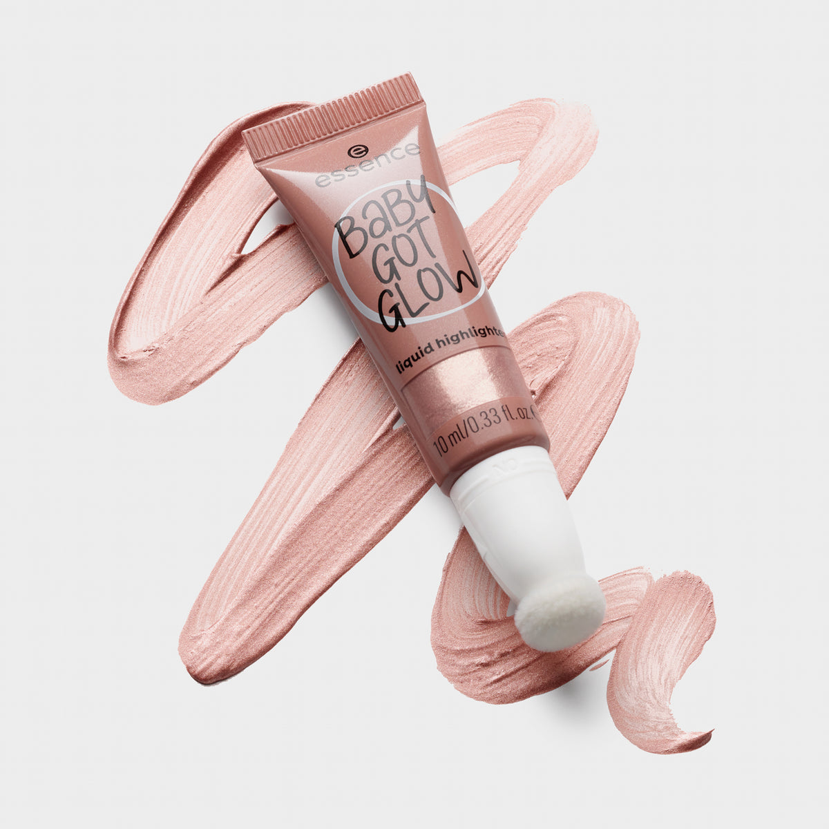 Tube BABY GOT GLOW liquid highlighter 20 liegt auf einem verwischten Farbstreifen auf grauer Oberfläche.