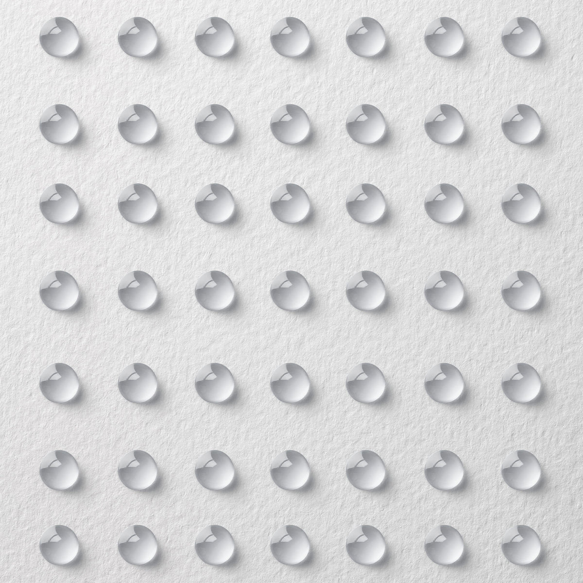 Gleichmäßig verteilte Tröpfchen des Supergel Oil-Free Moisturiser auf einer strukturierten weißen Oberfläche.