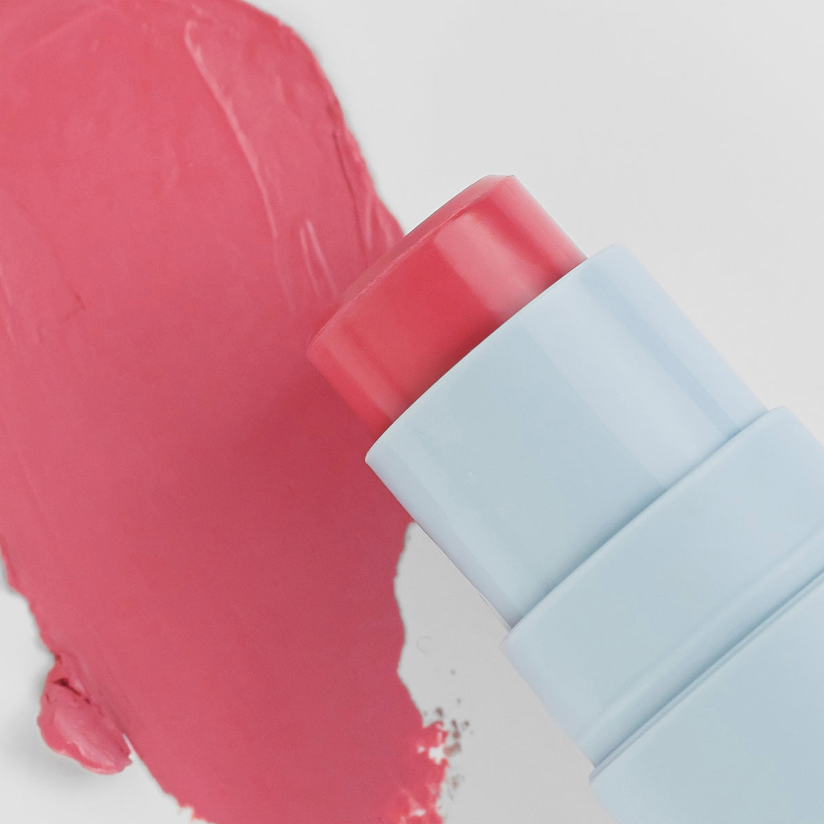 Nahaufnahme des Blush Stick - 2-in-1
Creme Rouge mit Pinsel in der Farbe Candy neben cremigem Farbmuster.