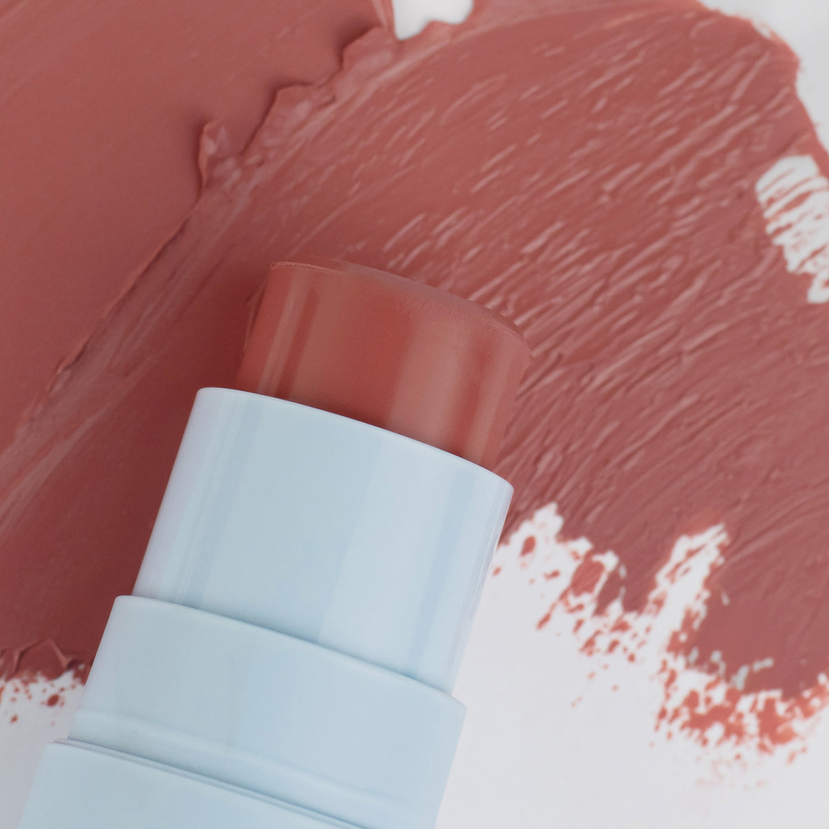 Nahaufnahme des Blush Stick - 2-in-1
Creme Rouge mit Pinsel in der Farbe Plum neben cremigem Farbmuster.