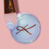 Der K1: Eye & Lip Glitter Pigment Brush liegt auf einem Tiegel Karla Cosmetics Glitter Pot auf rosa Hintergrund.