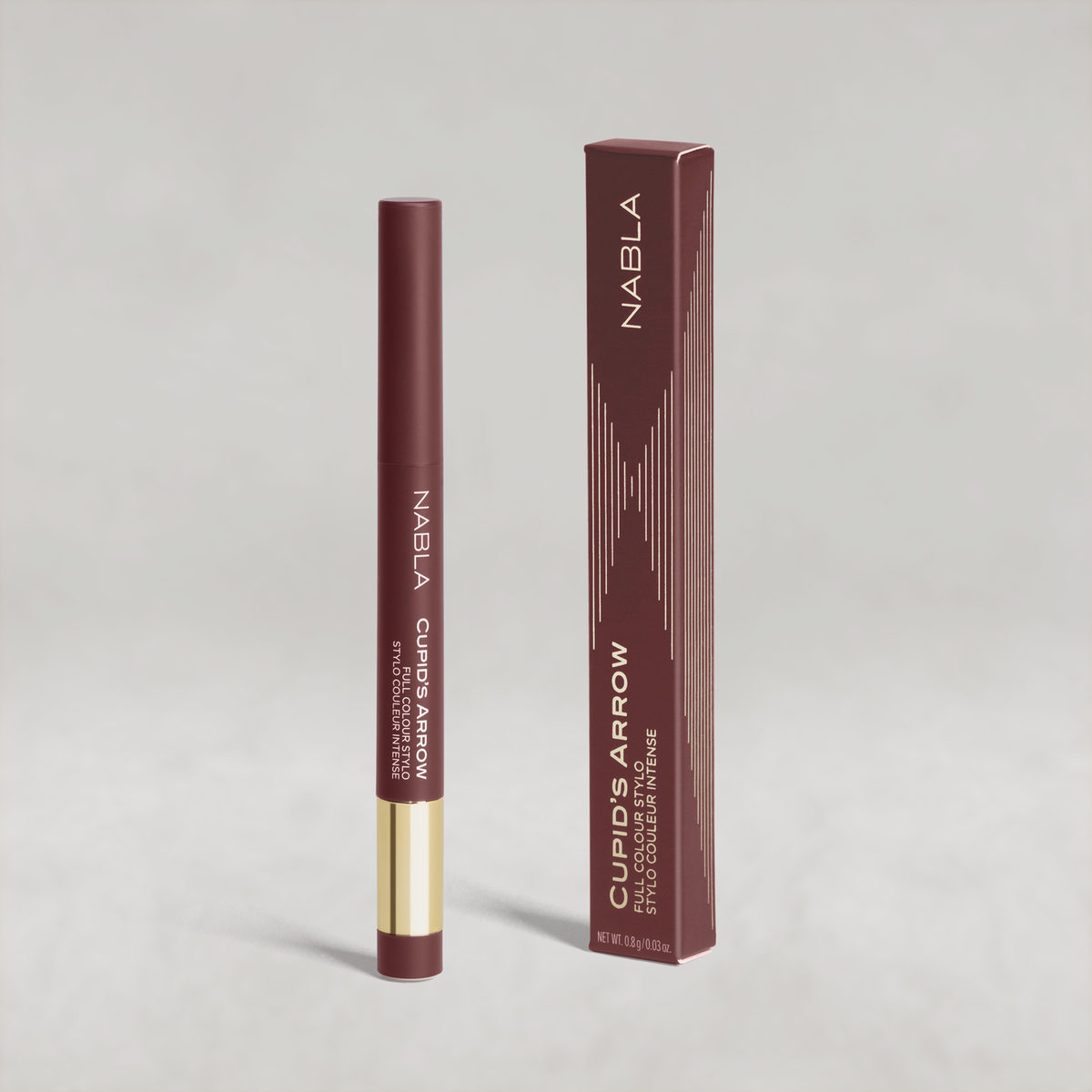 Beerenfarbiger Lidschatten-Stift mit goldener Kappe von NABLA neben der passenden beerenfarbiger Umverpackung mit goldenen Designelementen.