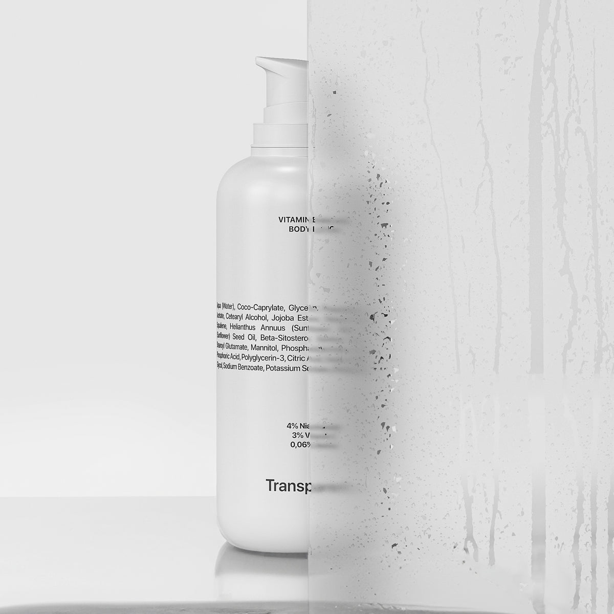 Hinter einem beschlagenen Glas ist eine weiße Flasche Vitamin Enriched Body Lotion zu sehen, wobei der Text teilweise verdeckt ist.