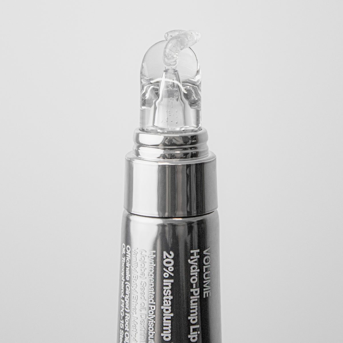 Silberne Tube Volume Hydrating Lip-Plumping Treatment mit einer klaren, gelartigen Applikatorspitze auf weißem Hintergrund.