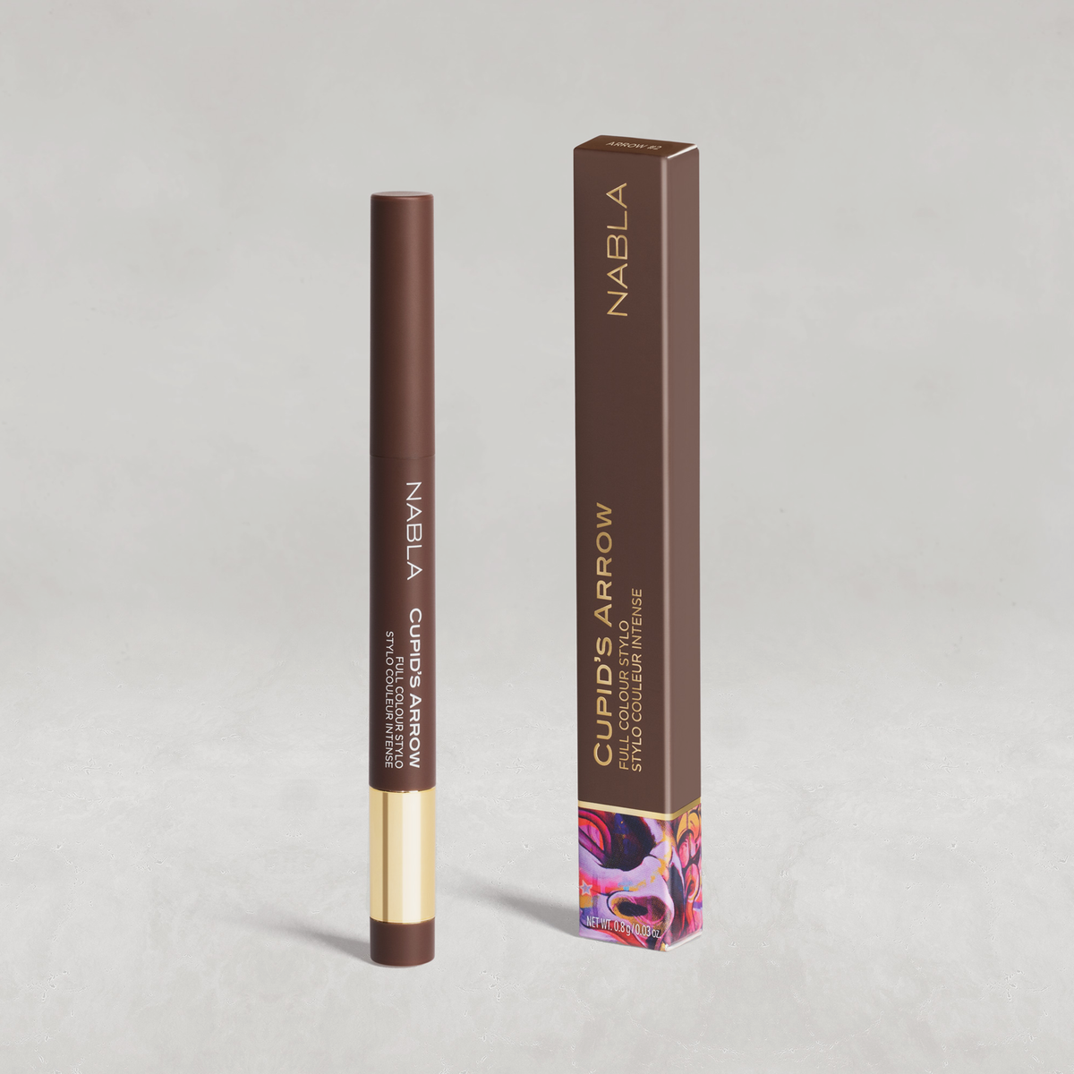 Ein brauner Cupid's Arrow Longwear Stylo Eyeliner-Stift steht neben der passenden Schachtel auf einem hellgrauen Hintergrund.